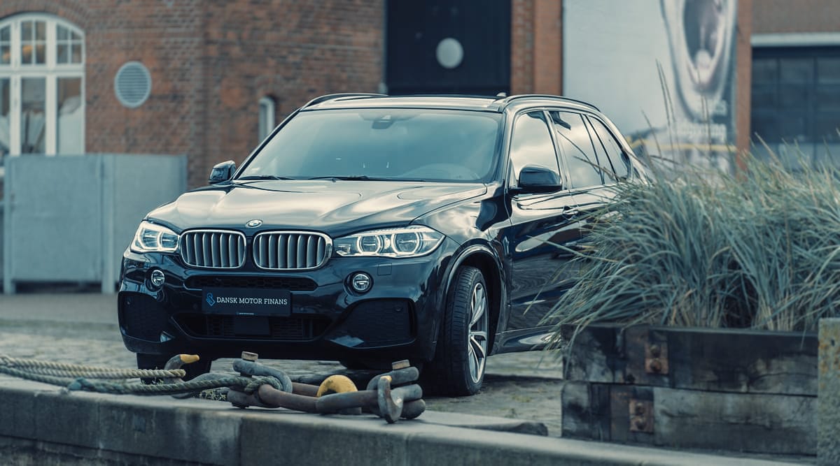 a black car parked in front of a brick building