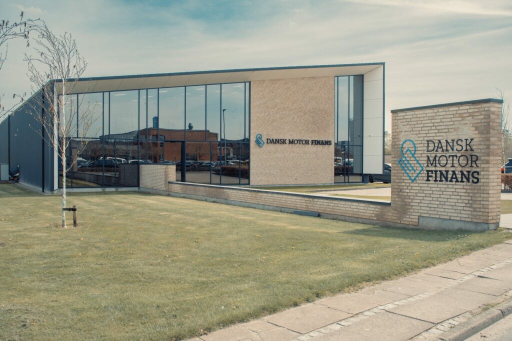 Partnerskaber 1 a building with glass walls and a lawn